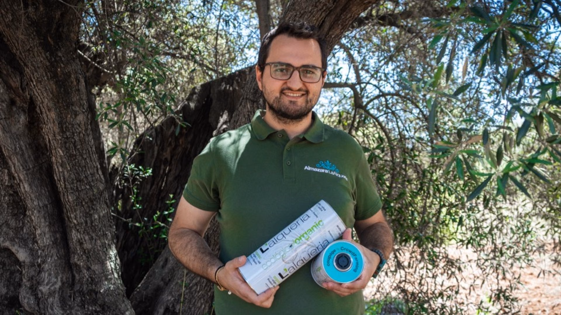 Uno de los productores con las latas de L'alqueria